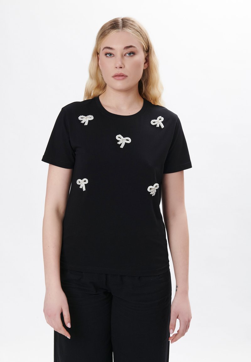 Schwarzes T-Shirt mit sechs kleinen, strukturierten, silbernen Bandapplikationen auf der Vorderseite. Rundhalsausschnitt, kurze Ärmel und eine taillierte Silhouette.