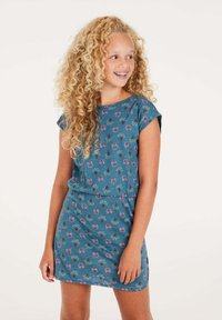 Tee-Kleid mit kurzen Ärmeln in Türkis, verziert mit einem Blumenmuster in Lila und Grün. Weicher Stoff mit lockerer Passform und Details an der taillierten Taille.