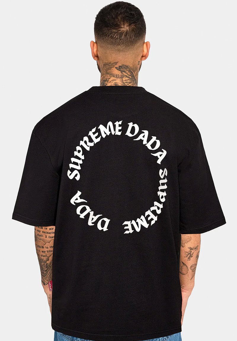 Schwarzes Baumwoll-T-Shirt mit einem geschwungenen weißen Textdesign, das auf dem Rücken "SUPREME DADA" liest. Lockere Passform mit kurzen Ärmeln.