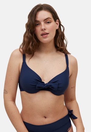 Top de bikini de color azul marino con un detalle de lazo en el centro. Presenta tirantes ajustables y una textura suave. Diseño clásico de bañador.