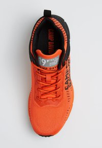 Orangefarbene Sportschuhe mit einem strukturierten Mesh-Obermaterial, schwarzen Akzenten, gesticktem Logo und einer gepolsterten Sohle. Verfügt über Schnürsenkel und eine Zuglasche.