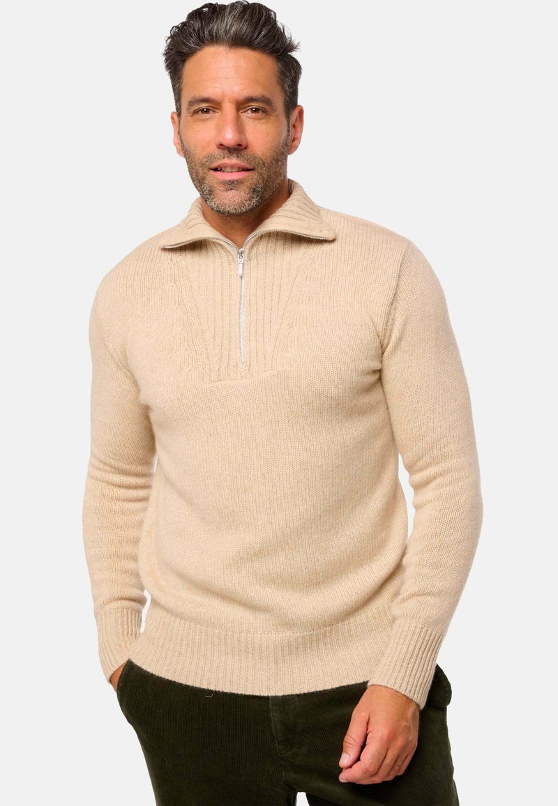 Beige Pullover mit Reißverschluss am Hals, mit gerippten Bündchen und Saum, ausgestattet mit einem strukturierten Muster am Kragen und oberen Brustbereich. Weicher Strickstoff.