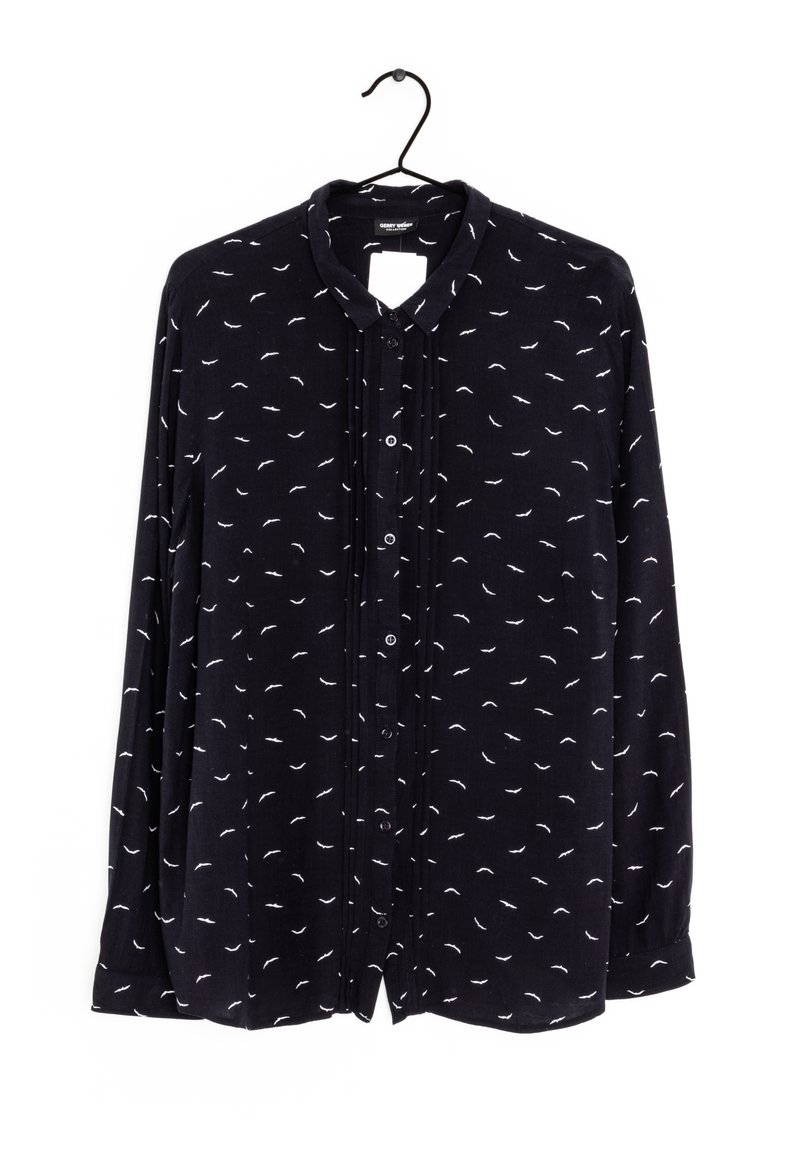 Blusa a maniche lunghe di un blu navy scuro con un piccolo motivo a piume bianche, fronte con bottoni e colletto classico. Tessuto morbido con una vestibilità leggermente ampia.