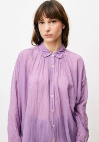 Lavendel button-up shirt met een zachte, gekreukelde textuur, met een kraag, knopen aan de voorkant en luchtige mouwen.