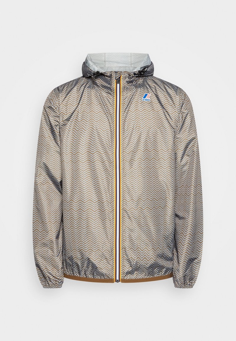 Veste légère à capuche avec motif zigzag marron et beige, fermeture éclair avant avec bordure jaune, poignets élastiques et logo sur la poitrine gauche.