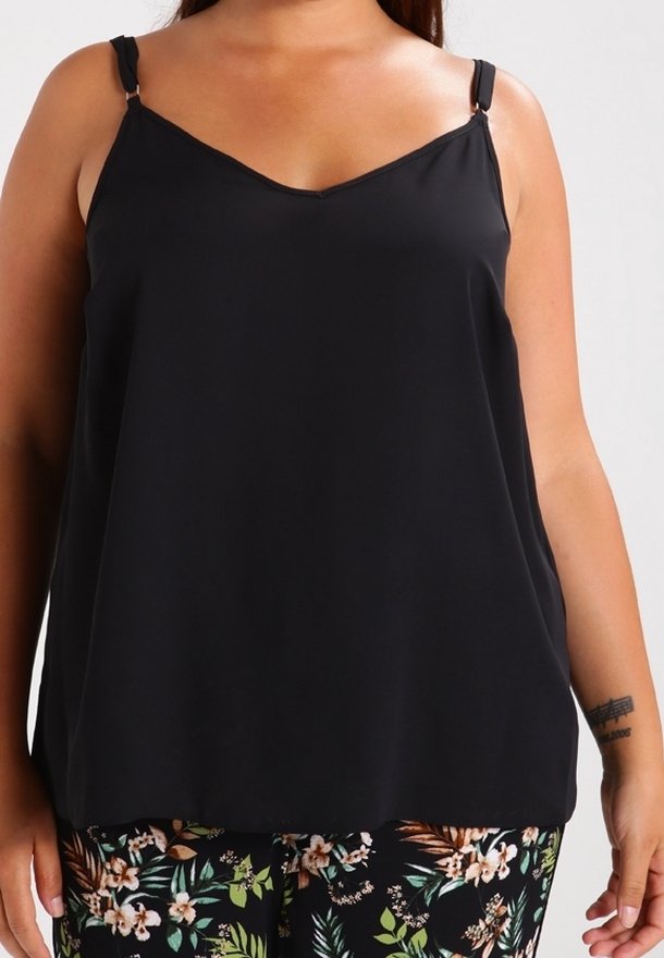 Blouse noire sans manches avec un décolleté en V, des bretelles minces et ajustables, et une texture lisse. Superposée sur un pantalon à motifs floraux.