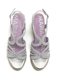 Sandalias plateadas con tiras, acabadas en un metal texturizado, con una plantilla lila y una suela de yute beige. Ajustadas con una hebilla lateral.