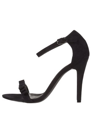 Czarna zamszowa sandałka na wysokim obcasie z cienkim paskiem wokół kostki, fałdowanym przednim paskiem i smukłym obcasem typu szpilka, oferująca minimalistyczny design.