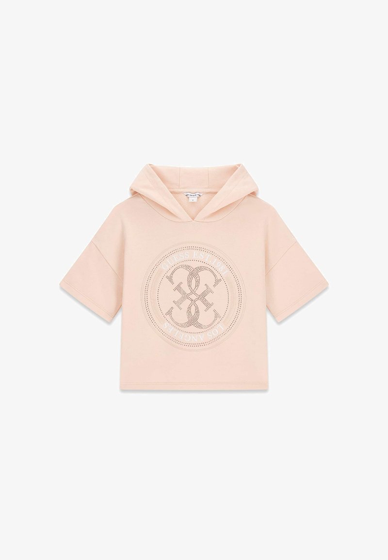 Hoodie court à manches courtes de couleur rose pâle, avec un logo circulaire perforé et le texte "Guess Est. 1981 Los Angeles" sur le devant.