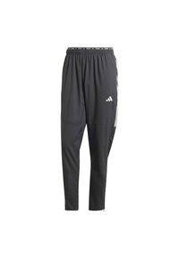 Schwarze Sporthose aus leichtem Material, mit tailliertem Schnitt, elastischem Bund und weißen Streifen an den Seiten.