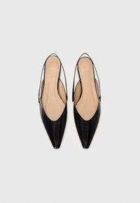Black pointed-toe slingback heels with a glossy finish. Features an open back and a smooth beige insole. Simple and elegant design.