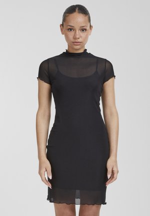 Black, form-fitting dress made of transparent fabric with a high neck and short sleeves, featuring a knee-length hemline and scalloped edges.