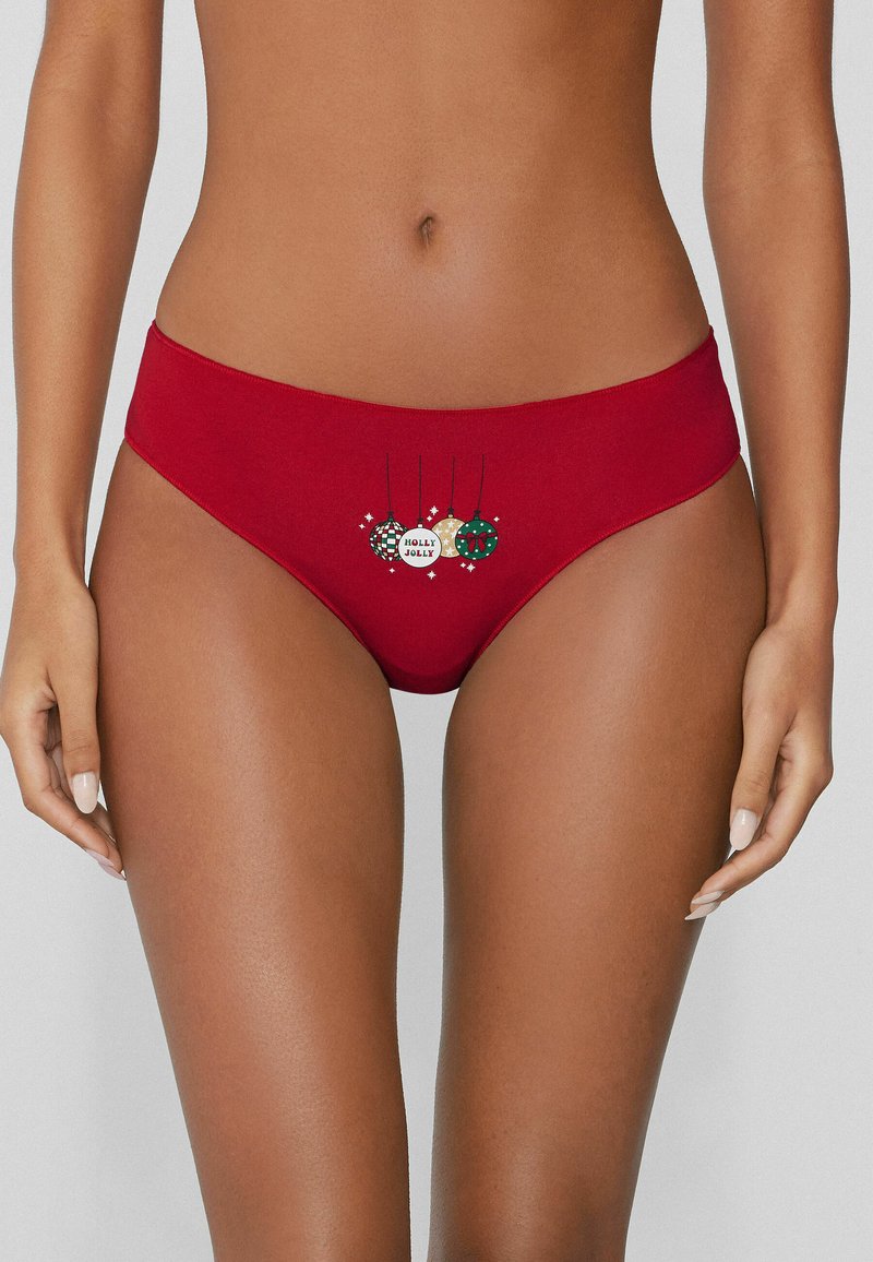Calzoncillos tipo hipster de algodón rojo con estampados navideños de adornos y texto "HOLLY JOLLY" en el frente, textura suave y cintura elástica.