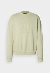 Lichtgroene crewneck trui met geribbelde manchetten en zoom, met geperst "HUGO"-tekst gecentreerd op de voorkant.