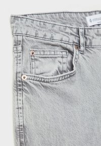 Vaqueros de denim gris con un ligero brillo, que cuentan con un bolsillo frontal, herrajes en tono cobre y una etiqueta tejida en la cinturilla.