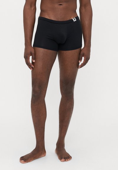 Schwarze Boxer-Shorts aus weichem Material mit enger Passform. Sie verfügen über einen verstärkten Bund mit einem kleinen Logotag auf der Vorderseite.