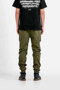 Olivgrön cargobyxor med avsmalnande benslut, sidofickor, tillverkade av slitstarkt material. Kombinerade med en svart t-shirt med grafik och svarta sneakers.