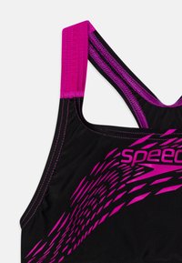 Zwarte sportbeha met roze bandjes. Het ontwerp omvat een roze grafisch patroon en contrasterende stiksels voor extra detail.