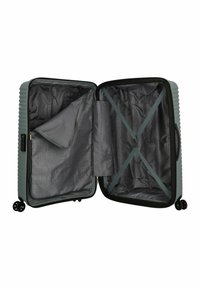 Valise rigide de couleur vert foncé, dotée d'un design texturé à stries, d'un intérieur ouvert avec un revêtement gris, d'une poche en maille et de sangles croisées.