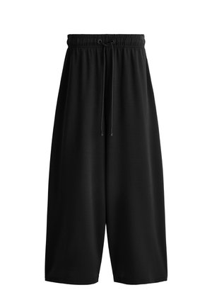 Černé široké kalhoty ke kotníkům s elastickým pasem a nastavitelným šňůrkovým zavázáním vpředu, vyrobené z hladké látky.