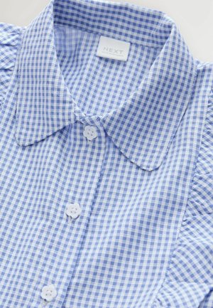 Chemise à carreaux bleu clair et blanc avec un col pointu, dotée de trois boutons blancs et de subtils détails froncés aux coutures des épaules.