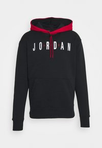 Sweat à capuche noir avec capuche doublée de rouge et cordons, avec le texte "JORDAN" en lettres blanches et rouges sur la poitrine, poche kangourou à l'avant.