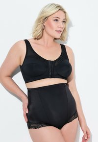 Reggiseno nero con rifiniture in pizzo e chiusura frontale, abbinato a slip neri a vita alta con accenti in pizzo all'orlo. Texture liscia.