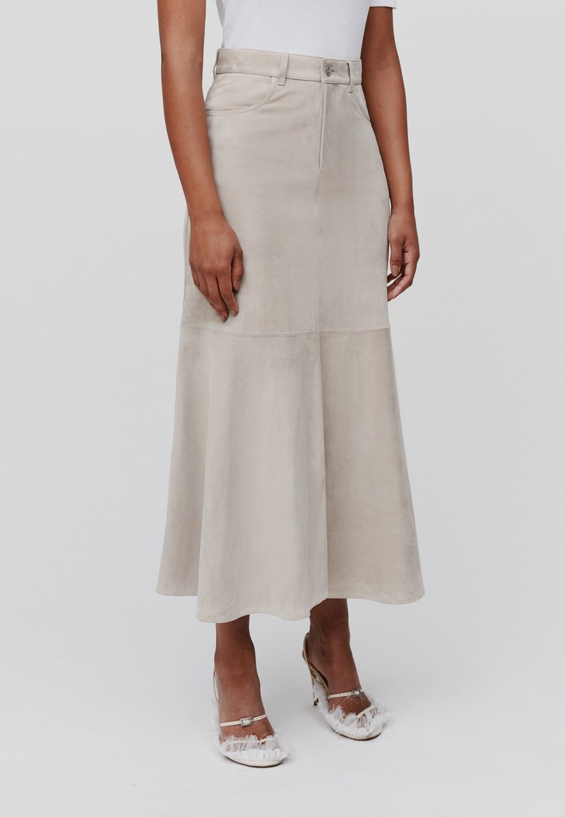 Beige Wildleder-Midikleid mit ausgestelltem Saum, hoher Taille, vorderem Knopfverschluss und dezenten Nähdetails.