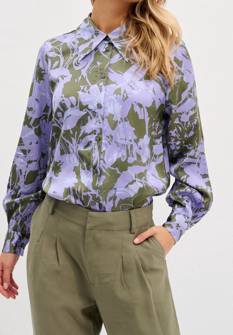 Blusa di raso con un motivo floreale astratto in viola e verde oliva, colletto, maniche lunghe e chiusura con bottoni.