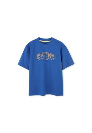 Blue cotton t-shirt featuring a crew neck, short sleeves, and a printed "Timberland" logo in gold. Smooth texture, casual fit.