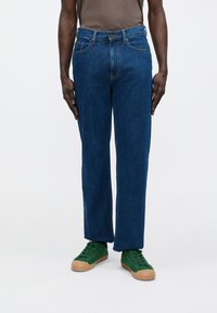 Zilas džinsa bikses ar taisnu kāju griezumu, klasisku piecu kabatu dizainu, metālisku pogas aizdari un smalku izbalējuma detaļu.