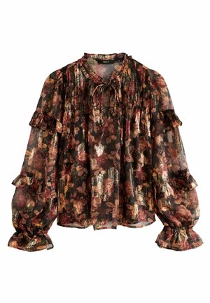 Genomskinlig svart blus med blommönster i rött, guld och grönt. Har volangärmar och knytning i halsen. Texturerat tyg med mjuk lyster.