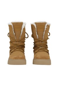 Botas de ante marrón con forro de piel blanca, con una punta redonda, diseño de cordones y suela plana de goma. Etiqueta de la marca en la parte delantera.