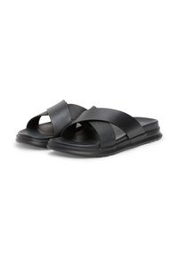 Black slide sandals featuring crossed straps in matte and textured materials. Flat EVA sole with light cushioning for comfort.