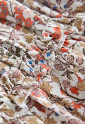 Stof floral cu un fundal bej deschis, având flori vibrante în nuanțe de portocaliu, roz și albastru. Textură ondulată cu detalii intricate.