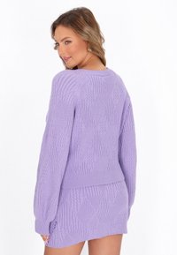 Maglione a maglia viola chiaro e gonnellina coordinata con motivo a rombi testurizzati, maniche lunghe e bordi a costine.