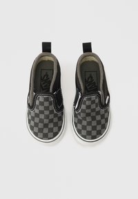 Sorte slip-on sko med gråt ternet mønster, hvid sål, elastiske sider og polstret gråt inderfor.