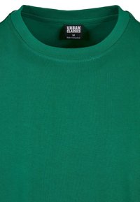 T-shirt en coton vert avec un col rond, présentant une texture lisse et une étiquette portant la mention "URBAN CLASSICS" à l'intérieur du col.