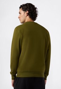 Olive green sweatshirt z okrągłym dekoltem, długimi rękawami i teksturowanym materiałem. Posiada ściśnięte mankiety i dół, minimalistyczny design.