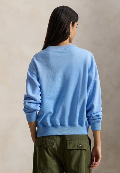 Ανοιχτό μπλε, άνετο φούτερ με χαλαρή εφαρμογή. Διαθέτει ριμπ μανσέτες και τελείωμα, μαλακή υφή και πίσω λαιμό χωρίς επιπλέον λεπτομέρειες.