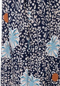 Marineblaues Gewebe mit einem floralen Muster in Creme und Hellblau, verziert mit orangenen Punkten und filigranen Blättern.