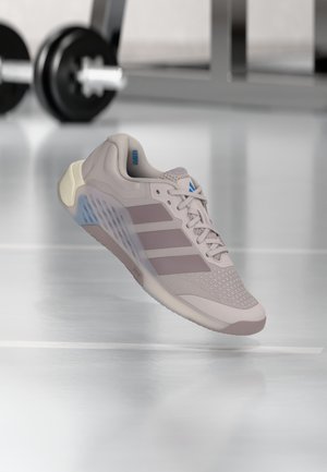 Světlounce růžová sportovní obuv s mesh svrškem, třemi horizontálními pruhy a polstrovanou podrážkou. Má modré akcenty a zaoblený design špičky.