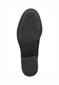Semelle de chaussure en caoutchouc noir avec des rainures texturées et des motifs circulaires. Présente une marque "GEOX", conçue pour l'adhérence et la ventilation.