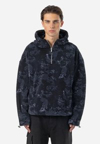 Svart fleece genser med hette, kvart glidelås foran og tonale abstrakte mønstre. Har et logo-patch på brystet og justerbare mansjetter.
