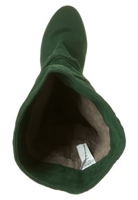 Bota alta de ante verde con un suave forro beige, diseño ligeramente caído y puntera redondeada. Etiqueta interior visible.