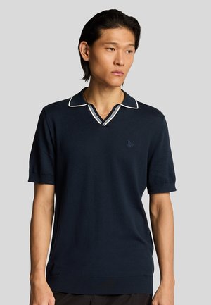 Marineblauw poloshirt met korte mouwen en een V-hals, witte kraag en mouwafwerking, met een subtiele geborduurde logo op de borst. Soepele textuur.