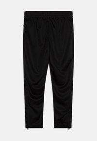 Zwarte sportbroek met een rekbare tailleband, taps toelopende vorm, gladde textuur en ritsmanchetten. Geschikt voor actieve kleding.