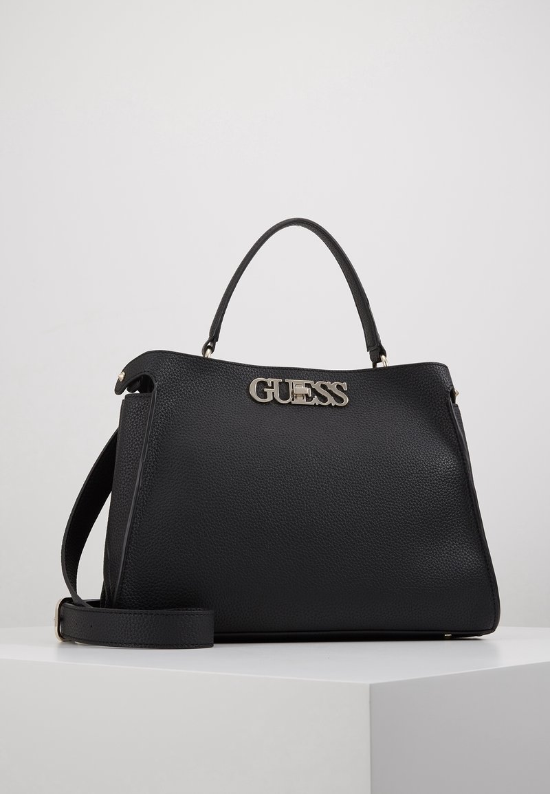 Sac à main en cuir noir à surface texturée, logo doré, poignées courtes et bandoulière amovible. Forme rectangulaire au design élégant.