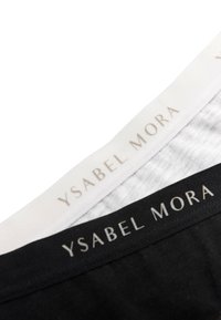 Dos pares de ropa interior con tela negra y blanca. Cada uno tiene una banda con el logotipo "Ysabel Mora" en un fondo dorado a lo largo de la cintura.
