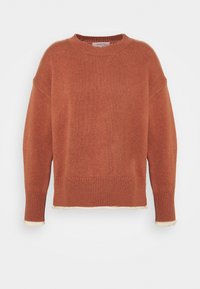 Pull en tricot couleur rouille à col rond, épaules dénudées, poignets et ourlet à côtes, avec une bordure contrastante crème aux bords.